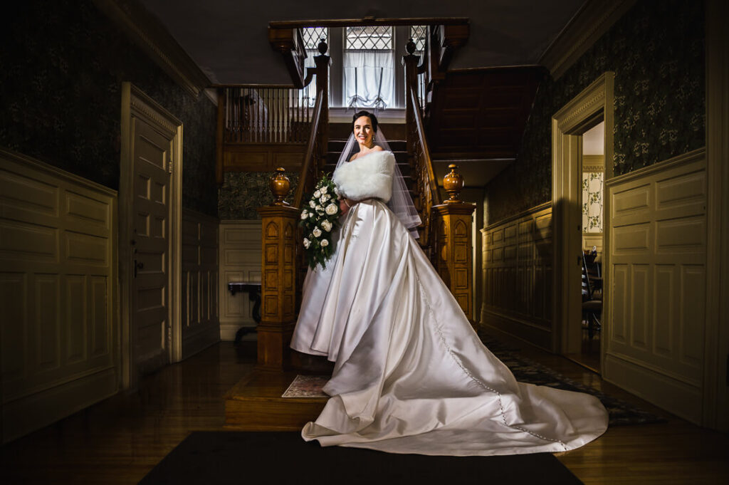 Bridal portrait standing on stairs at Franklin Manor B&B in Saranac Lake, New York