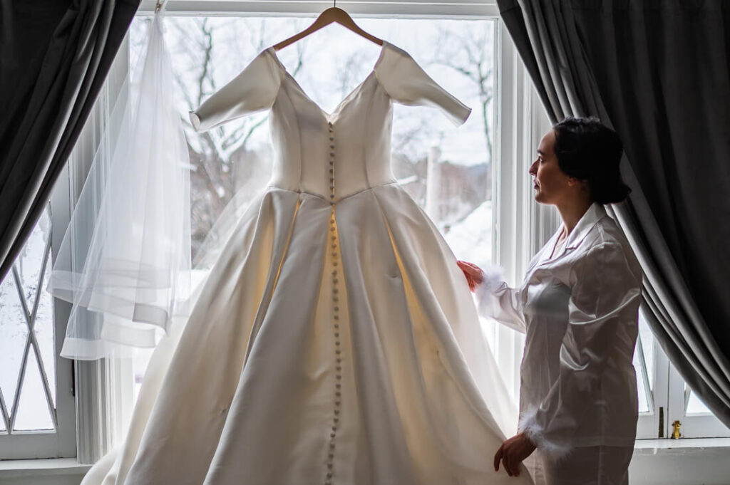 Bride with her wedding dress during Adirondack winter wedding at hotel saranac