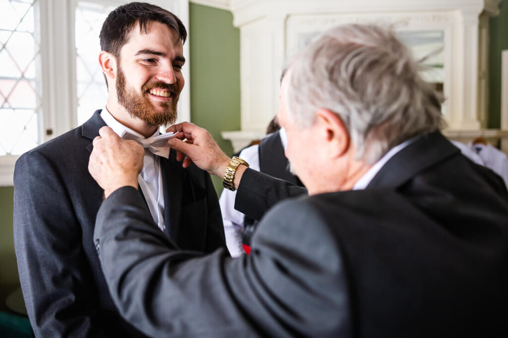 Father fixing grooms bow tie
