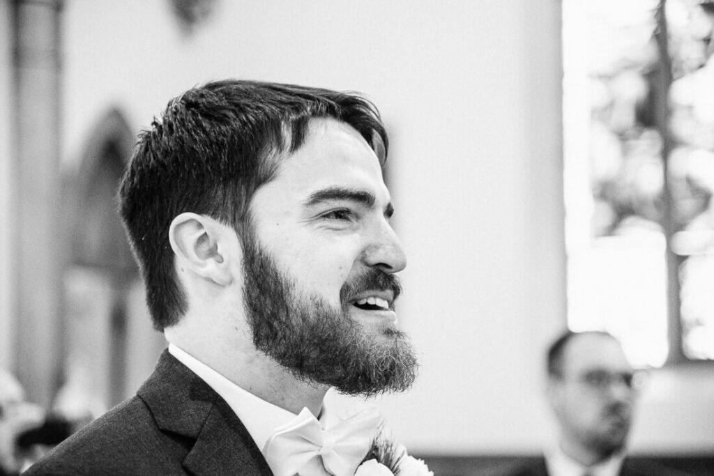 groom during wedding ceremony at St. Agnes Church in Lake Placid, New York