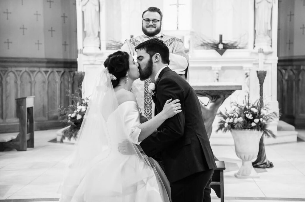 wedding couple first kiss at st agnes church in lake placid new york