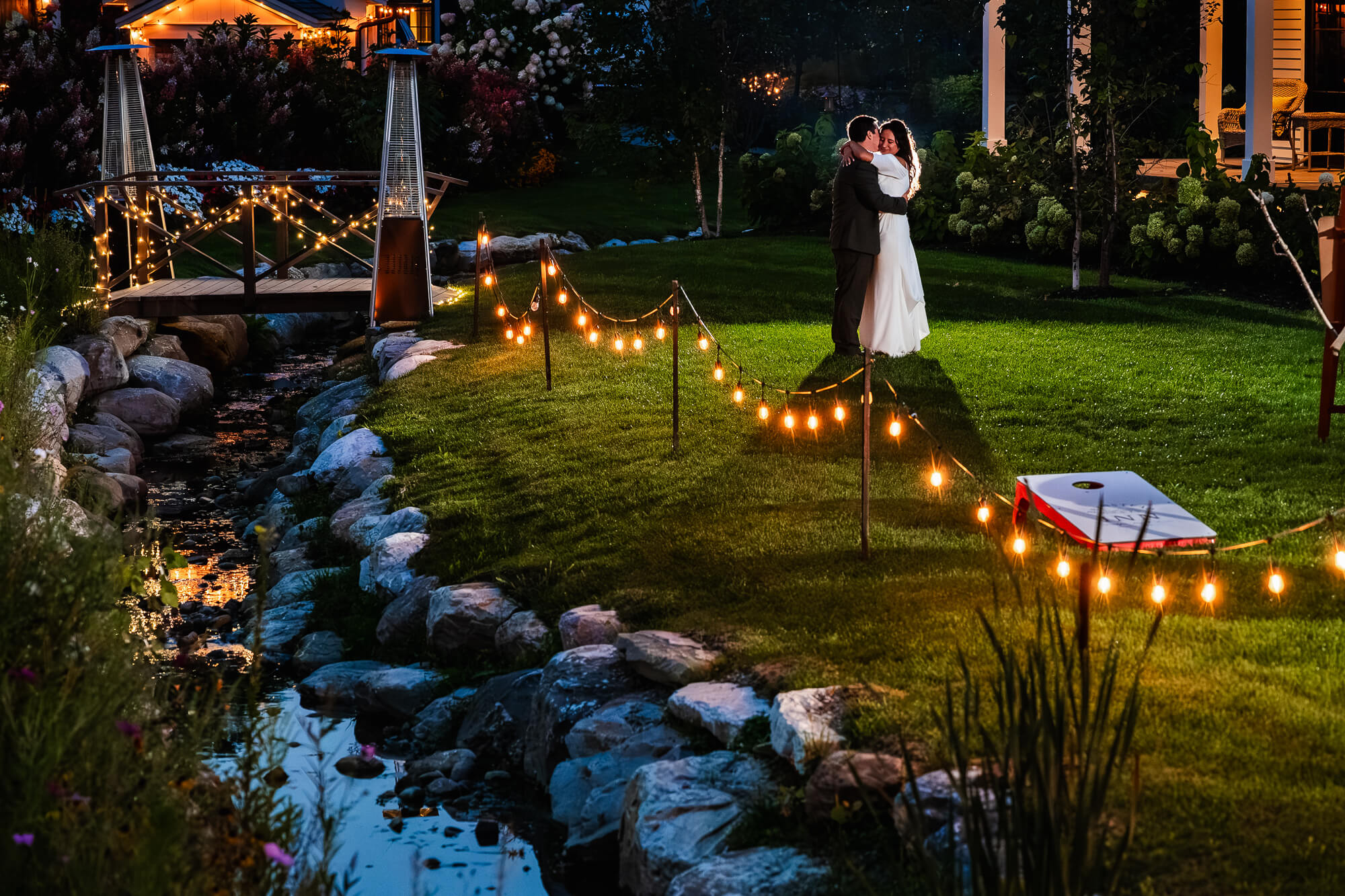 Couple embracing during quiet moment on Barnstead Inn grounds with twinkling lights and creative lighting